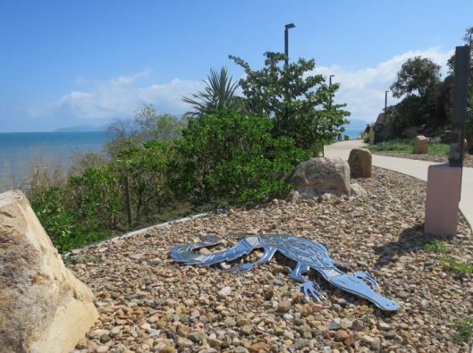 Image 5. A crocodile suns itself on rocks. In the background is Magnetic Island.